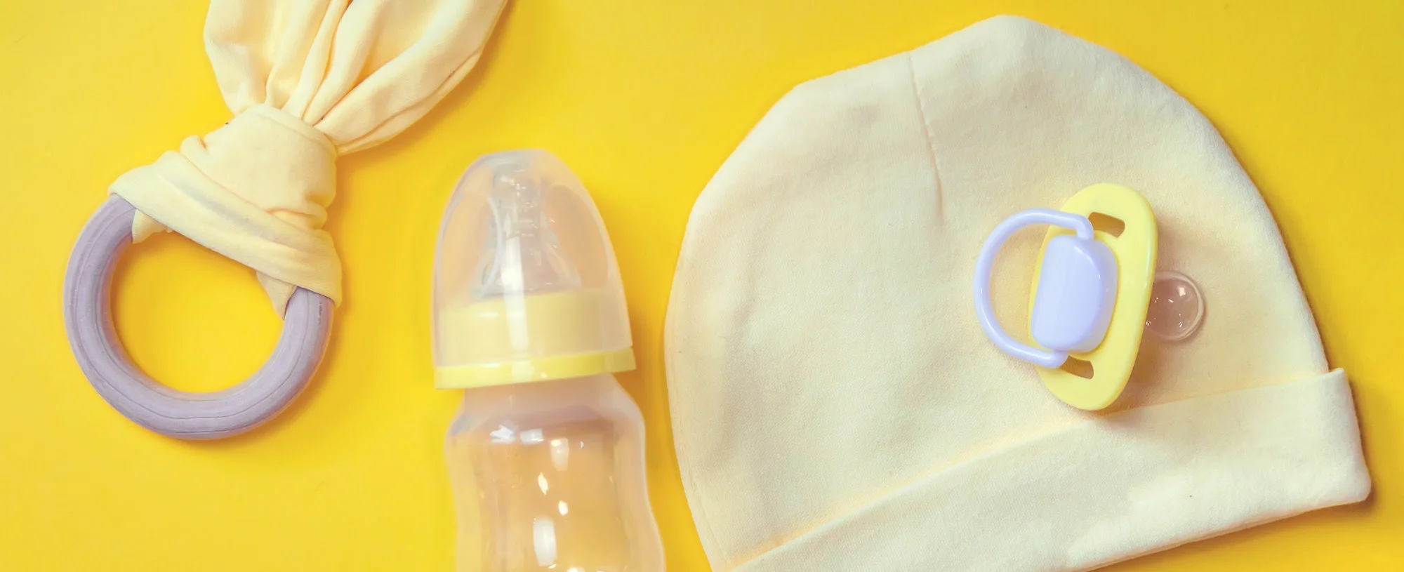 Accessories for newborns on a yellow background. Selective focus.