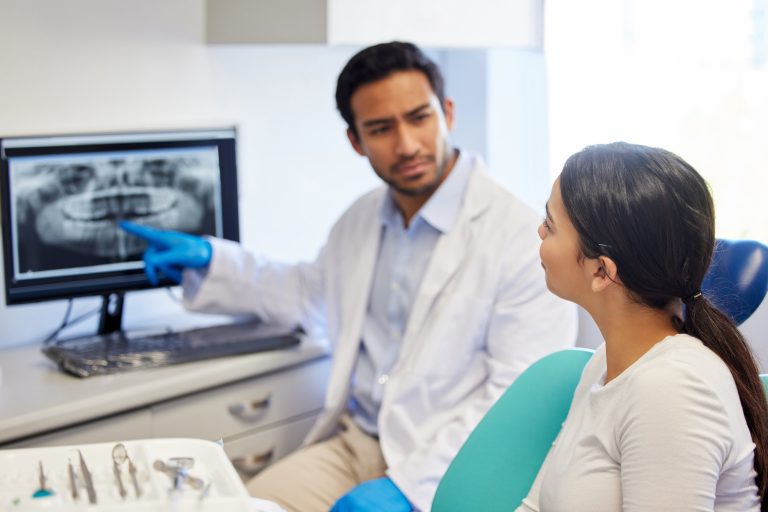 Shot of a dentist discussing the results of a patients teeth x ray