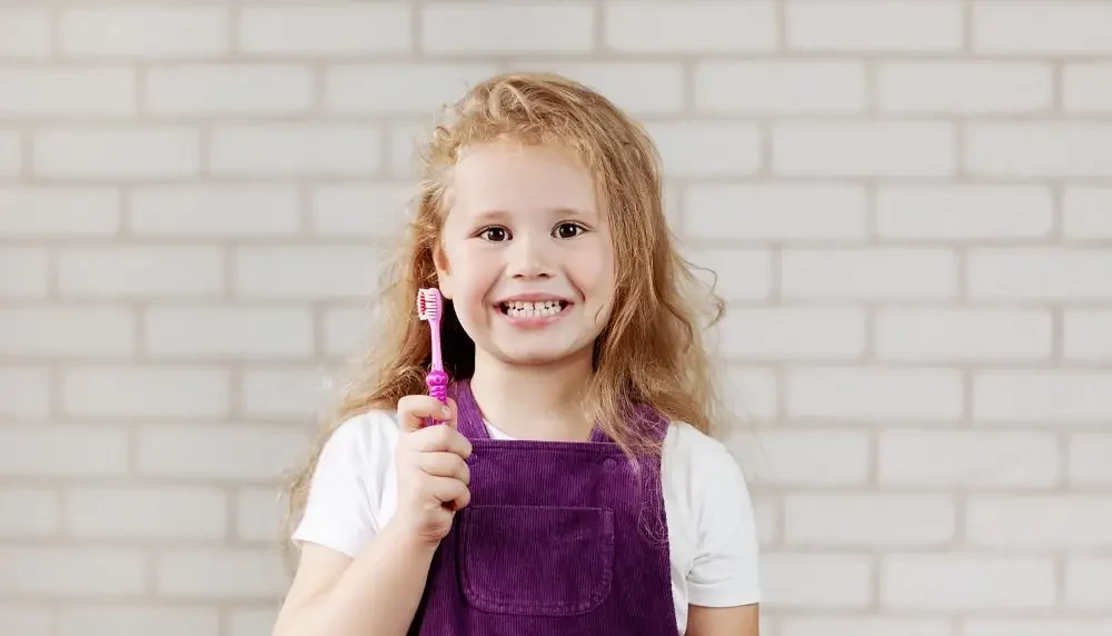 Kid holding a tootbbrush