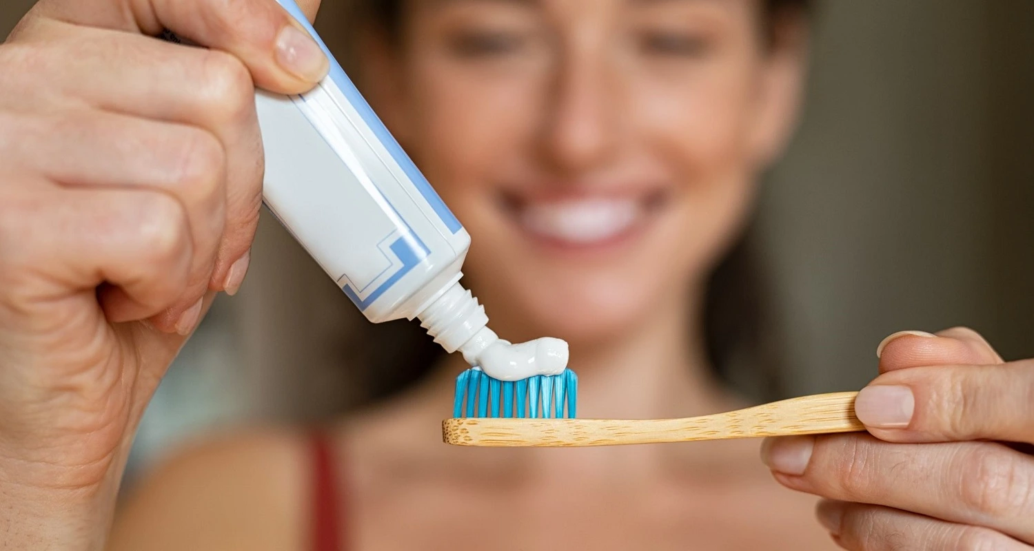 girl applying toothpaste