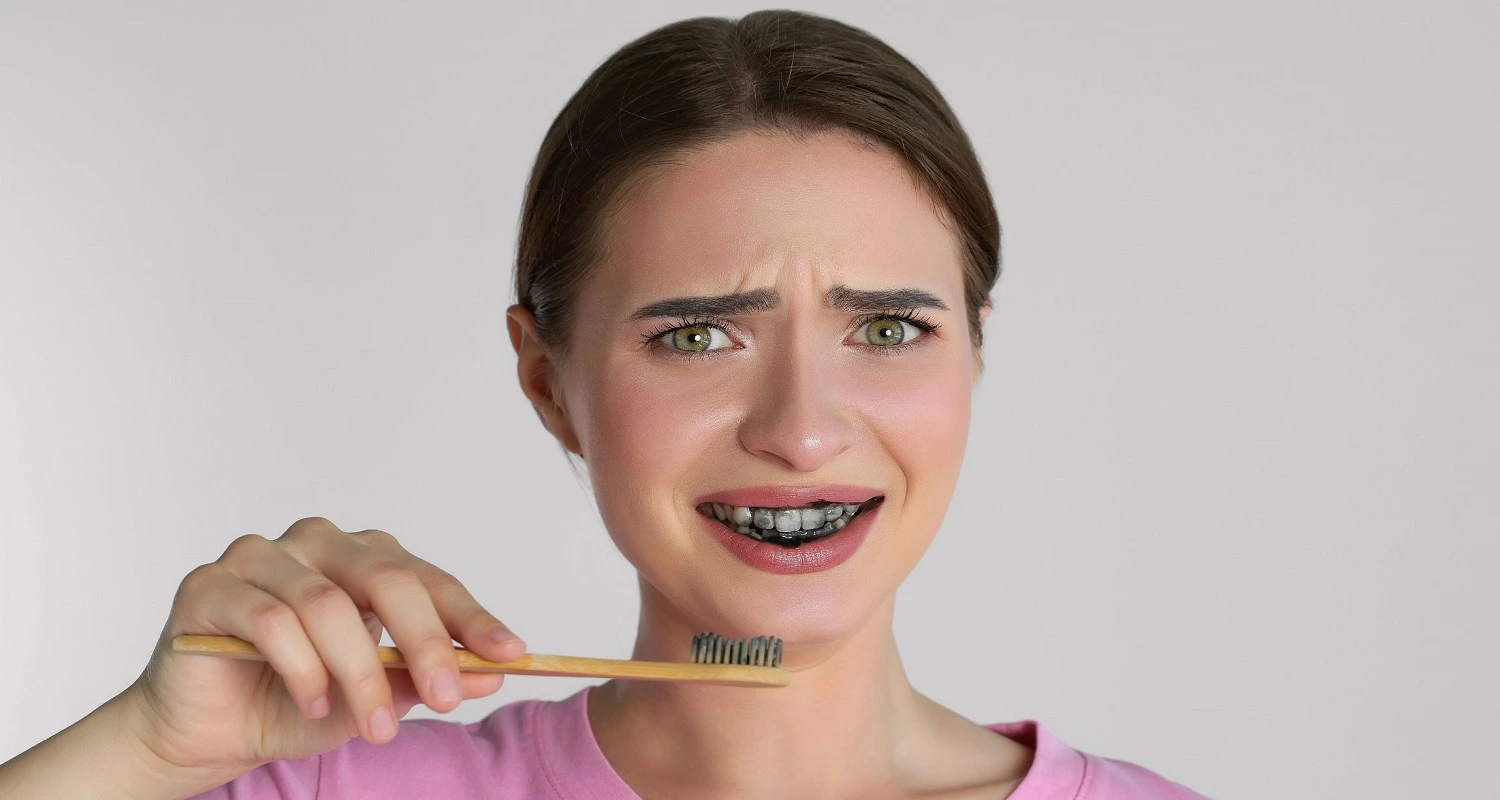 girl brushing with charcoal toothpaste