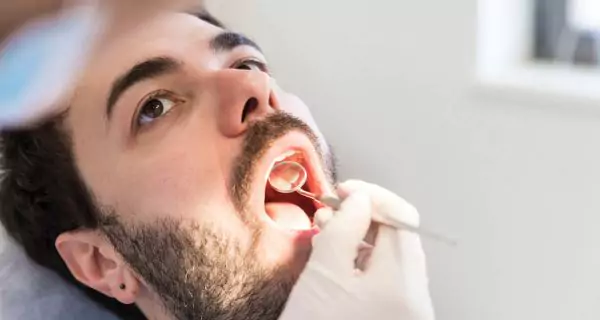 When should someone with ALS see a dentist?