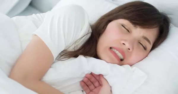 What happens during a seizure that causes teeth grinding?